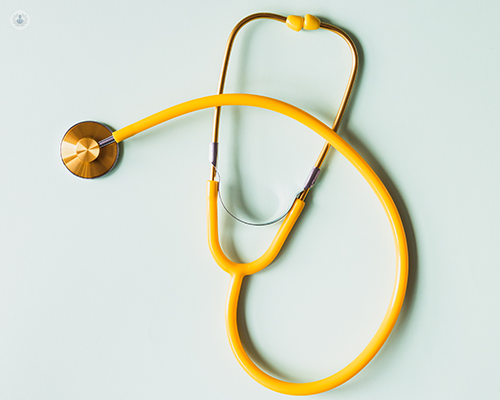 A yellow stethoscope on a light green background