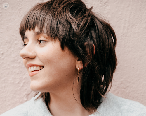 Young woman smiling after having gum recession treatment. 