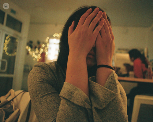 Young woman with anxiety covering her face