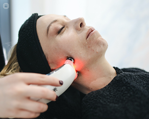 A woman receiving laser treatment on her face