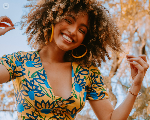 Smiling woman with fabulous afro hair, outside on a sunny day